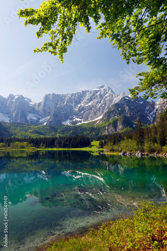 Picturesque mountain scenery and hiking place. Beautiful superior Fusine lake and Mangart mountain in background  Julian Alps  Tarvisio  Udine region  Friuli Venezia Giulia  Italy  Europe 