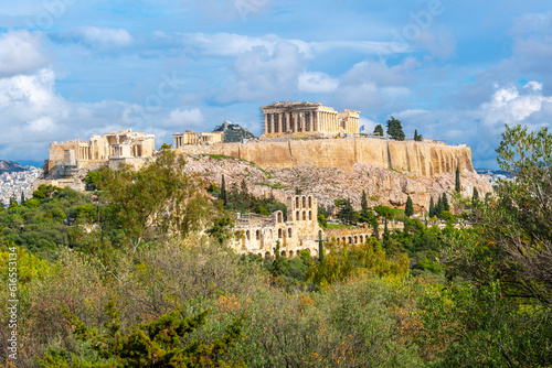 View from the top of Filapappou or Philopappos Hill of the Parthenon and Erechtheion on Acropolis Hill, with Mount Lycabettus in the background in Athens, Greece.	
