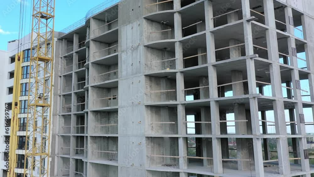 Aerial view of concrete frame of tall apartment building under construction in a city. Aerial view of concrete frame of tall apartment building under construction in a city.