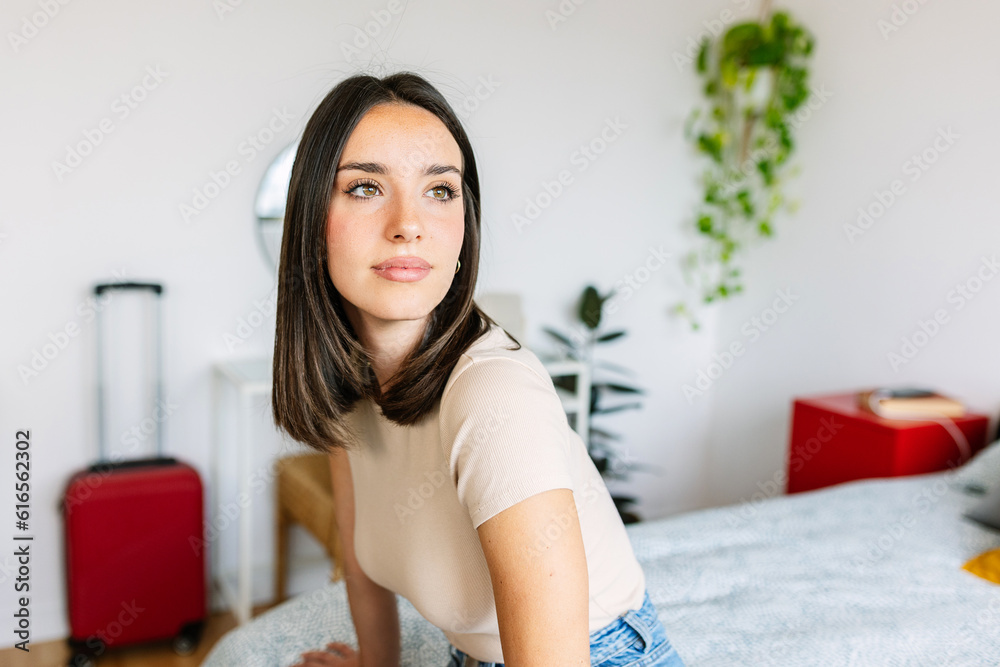Young pretty woman relaxing sitting on bed at home. Beautiful girl resting on bedroom looking at distance thinking. Home domestic lifestyle concept. Young pretty woman relaxing sitting on bed at home. Beautiful girl resting on bedroom looking at distance thinking. Home domestic lifestyle concept.
