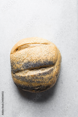 Top view of round homemade bread on a marble tray, Potbrood coated with sesame seeds photo