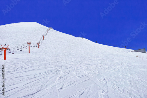 春スキーのニセコスキー場、綺麗な青空に映えるニセコアンヌプリ頂上、リフトとオフピステのシュプール

