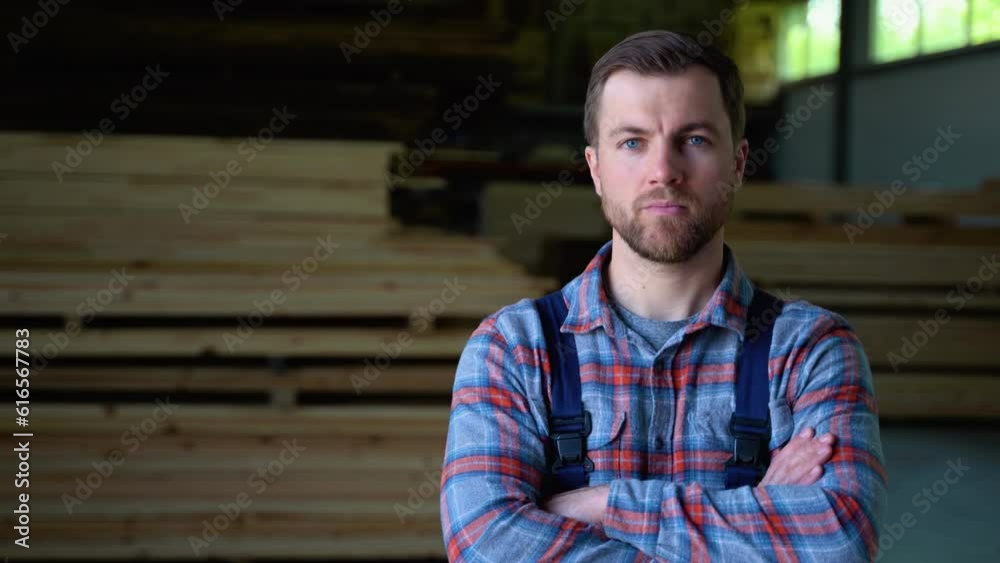 Carpenter in uniform check boards on sawmill