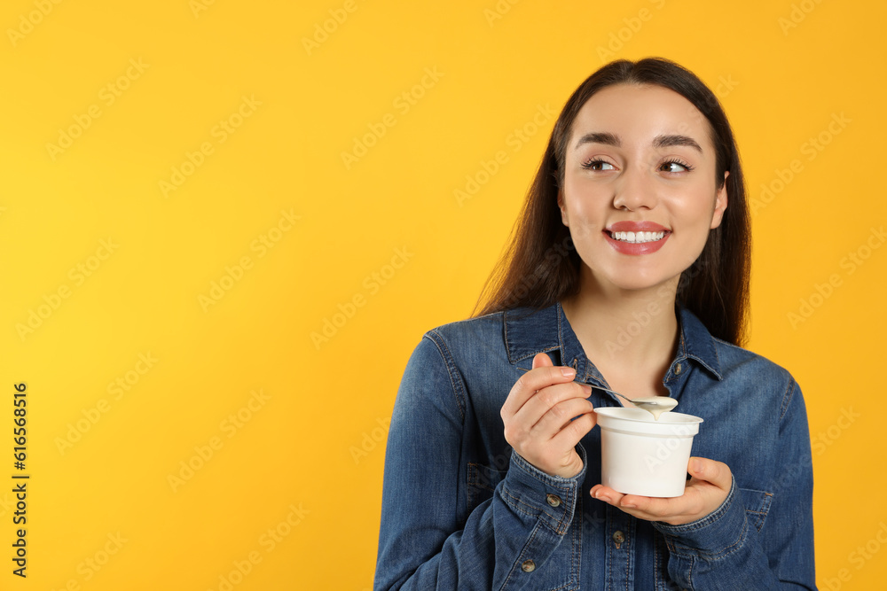 Happy woman with tasty yogurt on orange background. Space for text Happy woman with tasty yogurt on orange background. Space for text