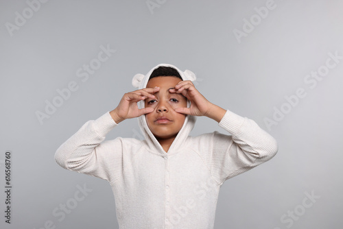 Sleepy boy in pajama on grey background. Insomnia problem