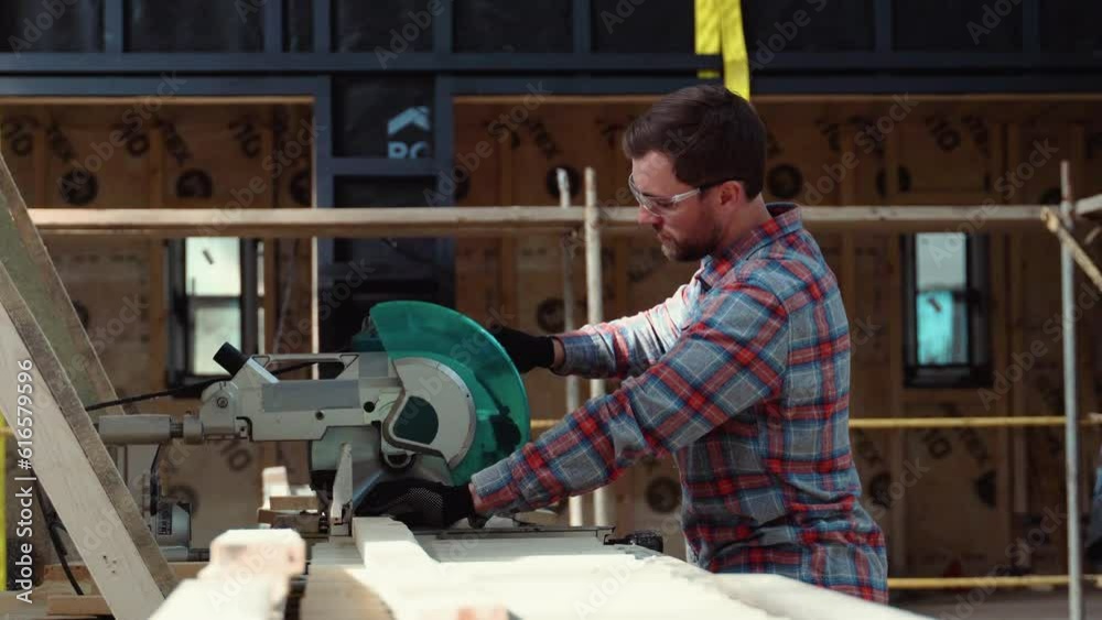 Builder saws a board with a circular saw in the cutting a wooden plank Builder saws a board with a circular saw in the cutting a wooden plank
