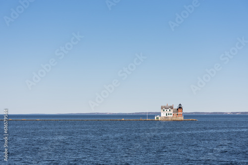 View of Rockland Breakwater Lighthouse, Maine. Clean horizon, deep blue ocean, and clear blue sky.