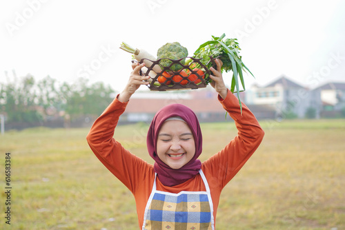hijab woman smile wear apron hold lift the basket above the head