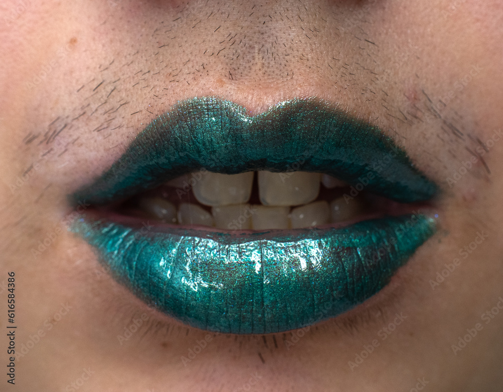 Close-up of a woman with a mustache wearing a metallic green lipstick with an open mouth Close-up of a woman with a mustache wearing a metallic green lipstick with an open mouth