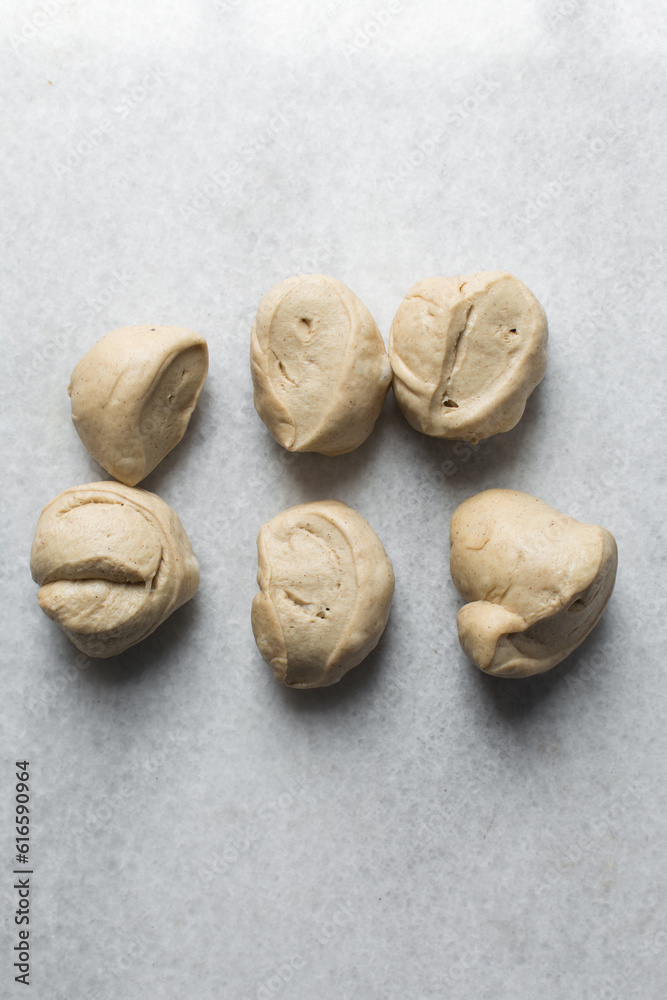 Bread dough divided into portions, process of making Swedish cinnamon buns or homemade Kanelbullar Bread dough divided into portions, process of making Swedish cinnamon buns or homemade Kanelbullar
