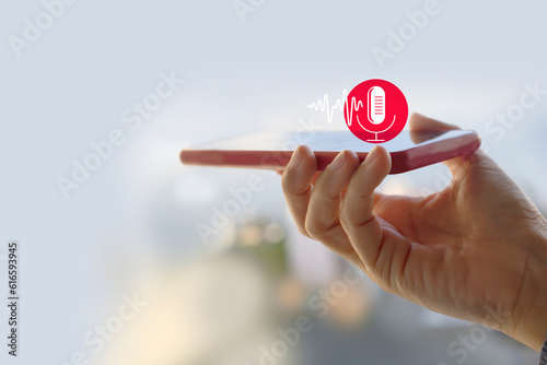 Voice recording. Hand holding microphone icon on smart phone. Mobile application Record sound, audio, music, voice message. or Use your voice to direct AI to search for information on Internet.
