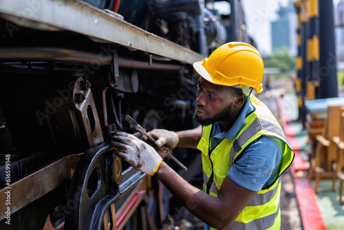 Engineer railway wearing safety gear checking train transmittal system for safety travel passenger