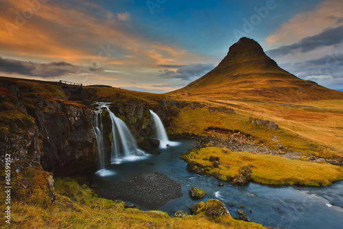 The famous Kirkjufell mountain waterfall in Iceland . Shot during sunset with slow shutter speed 