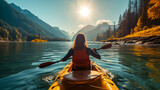 back view of woman kayaking in crystal lake near mountains