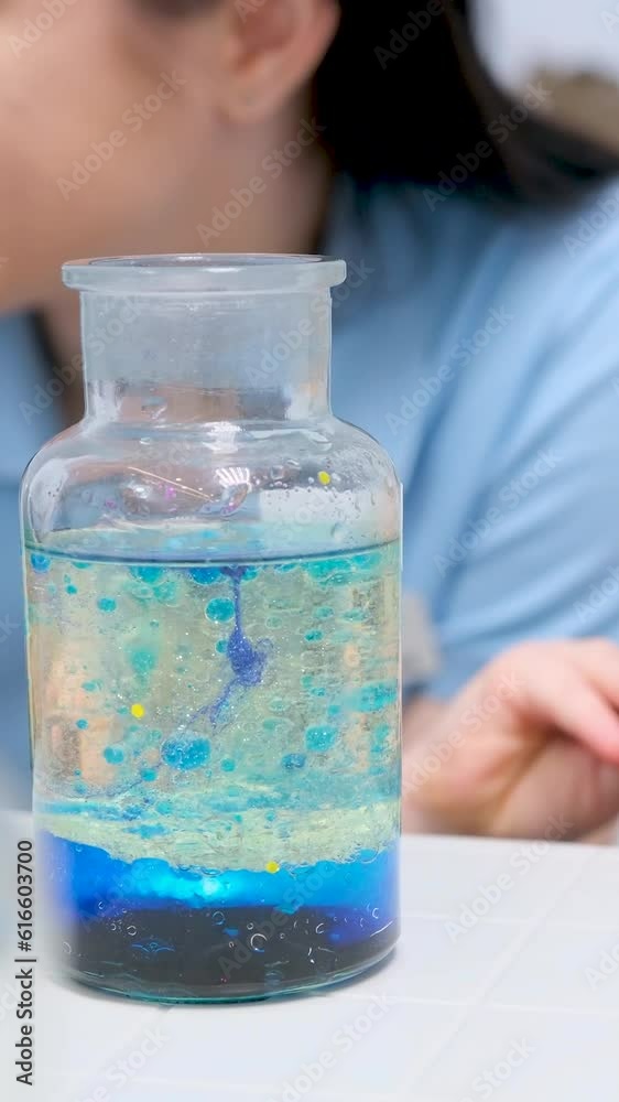 girl with pleasure and joy looks into bottle with bubbles she rubs eyes eyes are tired she is very happy Chemistry laboratory experiments girl with pleasure and joy looks into bottle with bubbles she rubs eyes eyes are tired she is very happy Chemistry laboratory experiments