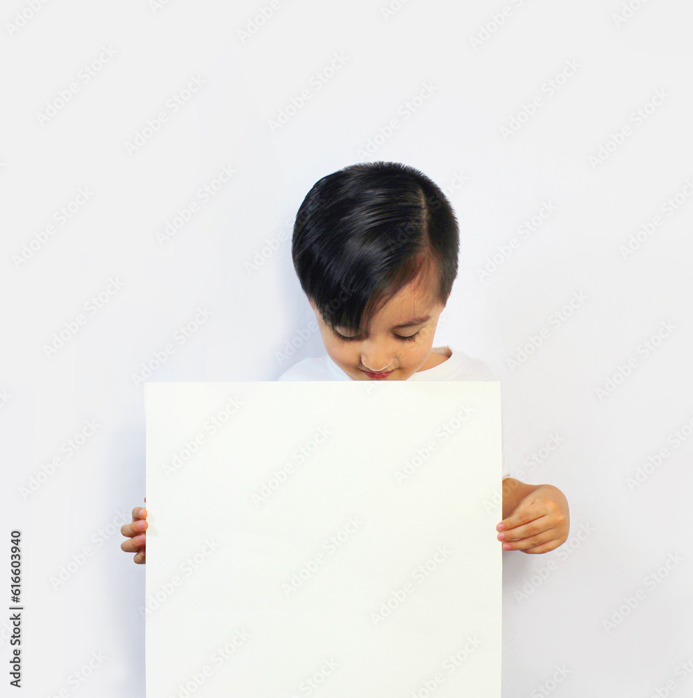 boy with head down, looking at a white piece of paper held in his hands wearing a white T-shirt on a white background boy with head down, looking at a white piece of paper held in his hands wearing a white T-shirt on a white background