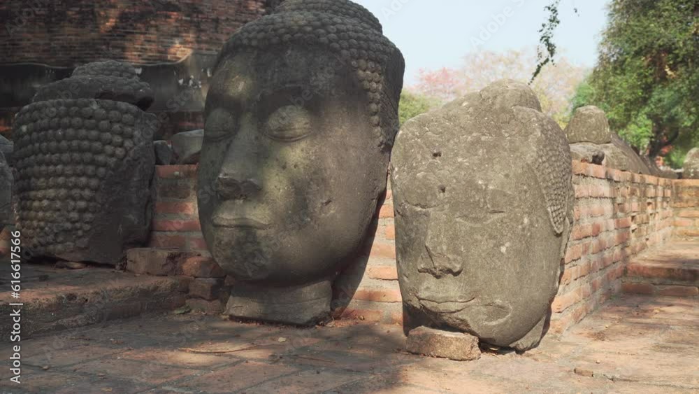 Stone heads of Buddha statues among ruins of Wat Ratchaburana