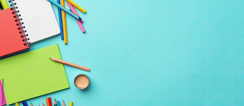A notebook, pencils, and other office supplies on a blue background created with Generative AI technology A notebook, pencils, and other office supplies on a blue background created with Generative AI technology