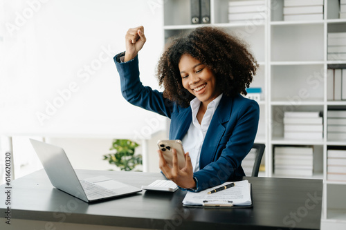 African business woman are delighted and happy with the work they do on their tablet, laptop and taking notes at the office.