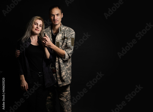 Happy woman hugging his husband came back from army. Smiling cheerful caucasian girlfriend embracing a soldier.