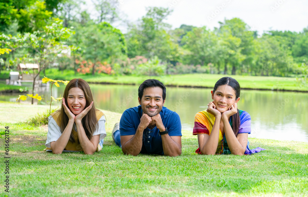 young diversity genders friends,man,woman and woman transgender enjoy leisure time in the summer park,lying on grasses take pleasure in nature,concept of people lifestyle,health benefit in nature young diversity genders friends,man,woman and woman transgender enjoy leisure time in the summer park,lying on grasses take pleasure in nature,concept of people lifestyle,health benefit in nature