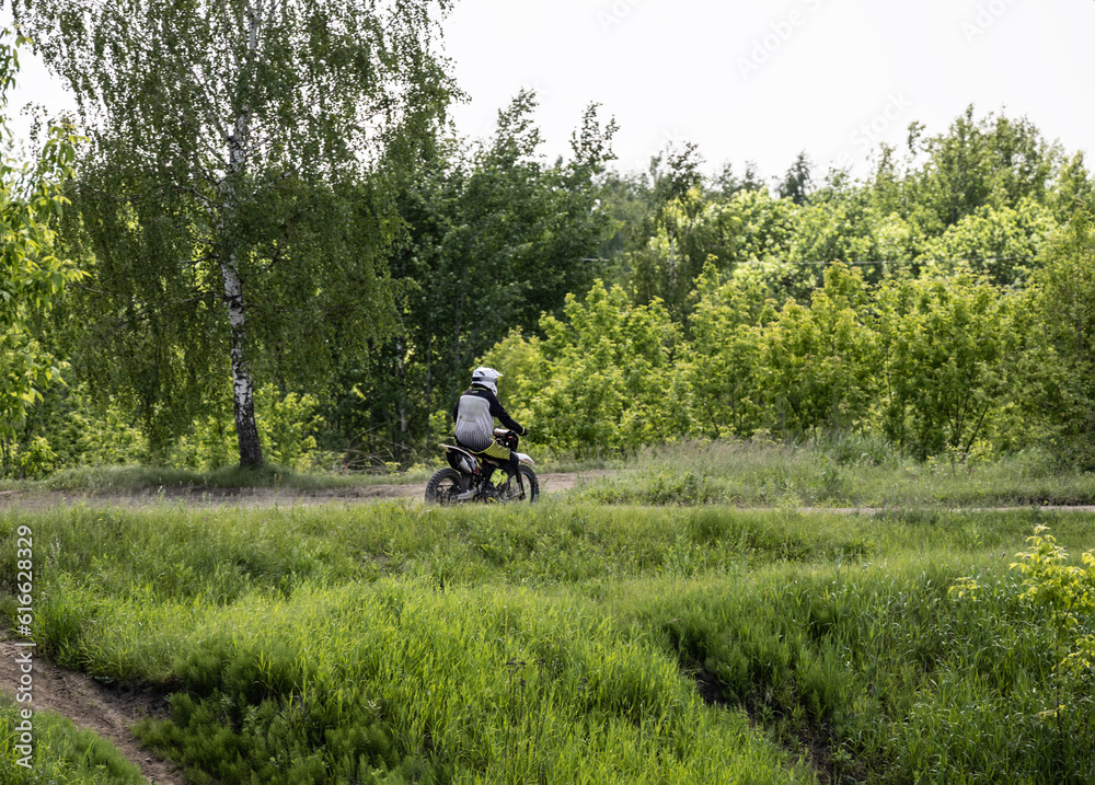 motorcyclists on a rural road against the backdrop of a forest on a summer day