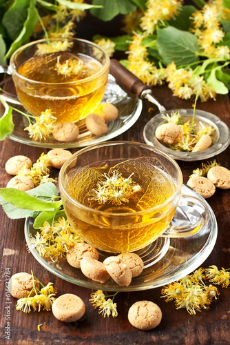 Cup of herbal tea with linden flowers on  old wooden table