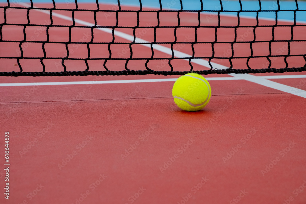 view of a ball in a red tennis court