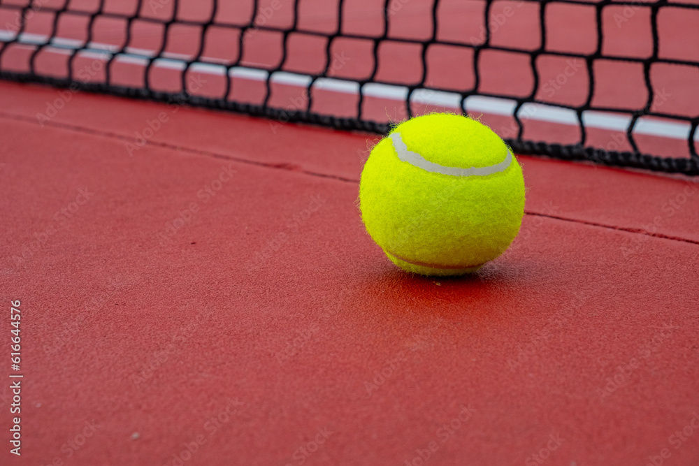view of a ball on a red tennis court
