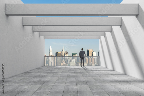 African businessman looking at city from office balcony