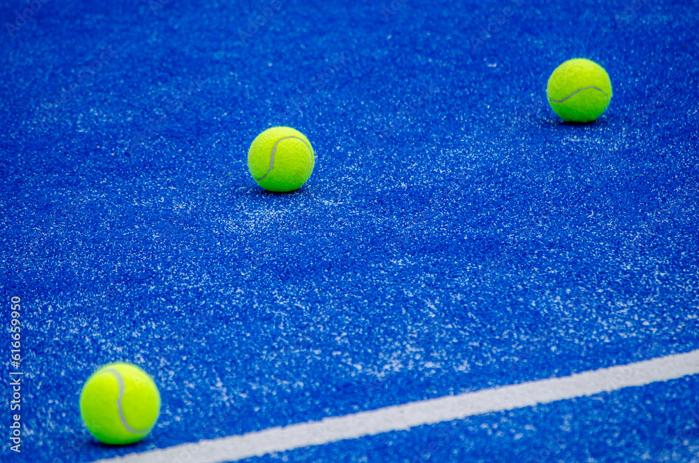 three balls on a paddle tennis court, racket sports
