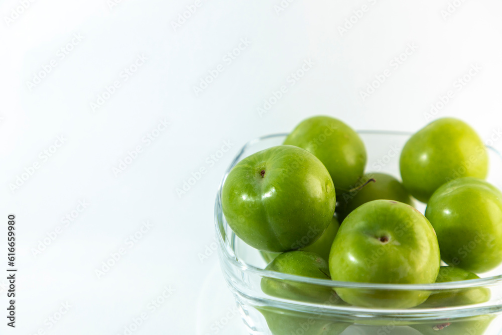 Delicious green plums in a transparent bowl Delicious green plums in a transparent bowl