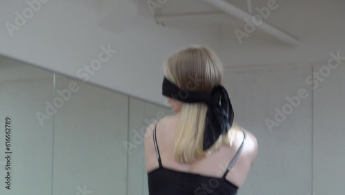 Young lady with black band on her eyes dancing in the Hall. Freedom Conception