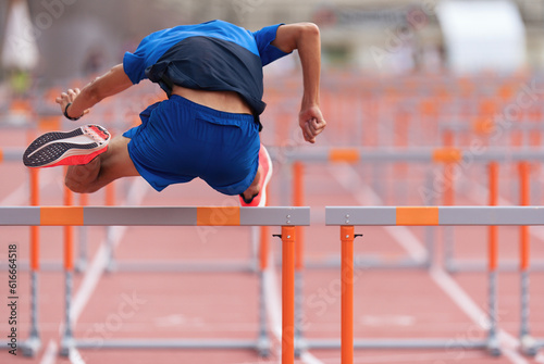 A hurdle runner leaping over the hurdles, man is jumping over the hurdle