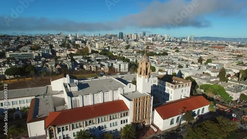 Aerial Panning Shot Of Mission High School In City Against Sky, Drone Flying Over Cityscape On Sunny Day - San Francisco, California
