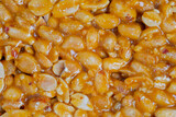 Caramelized nuts fried in honey - Gozinaki - orange granola peanut bar - close up, top view, macro. Traditional Georgian cuisine, oriental sweet, gastronomy and food concept