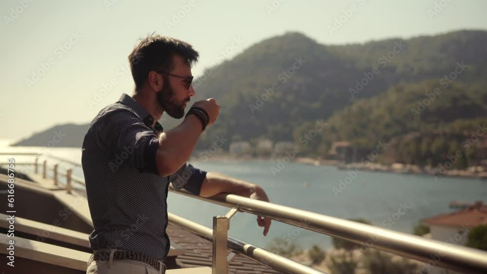Man looking at calm sea and drinking coffee on vacation Man looking at calm sea and drinking coffee on vacation