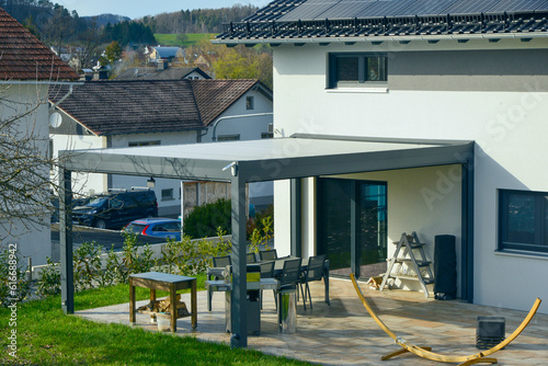 Canvastavla Sonnendach / Pergola als Sonnenschutz auf der Terrasse eines neu gebauten Wohnha