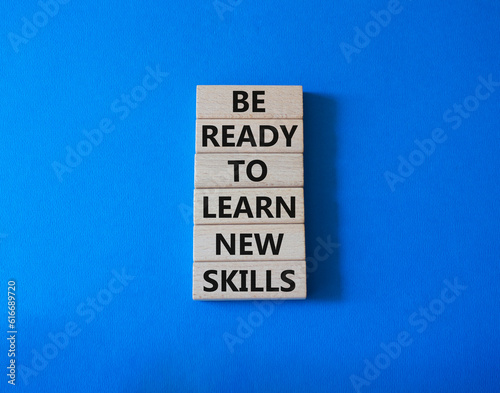 Learn new skills symbol. Concept words Be ready to Learn new skills on wooden blocks. Beautiful blue background. Business and Learn new skills concept. Copy space. © Natallia