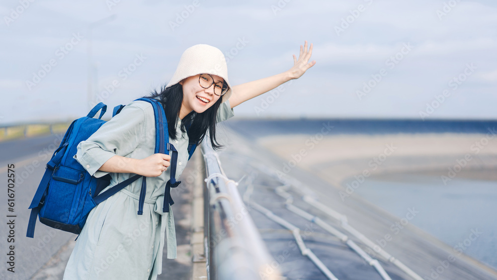 Happy asian traveler woman with blue backpack at outdoor on day