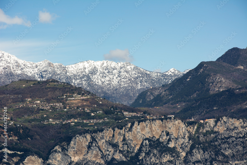 View of the big snowy mountains. There are small houses on the slopes of the foothills. Tourist scenic landscape