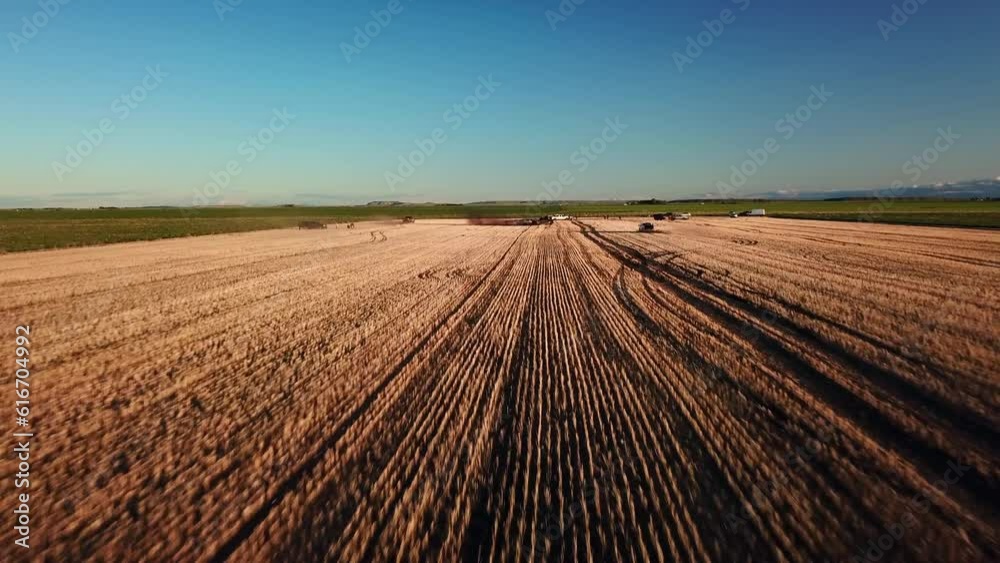 Aerial: Drone Flying Forward Towards Pickup Trucks Blowing Dust On Field Against Blue Sky - Billings, Montana Aerial: Drone Flying Forward Towards Pickup Trucks Blowing Dust On Field Against Blue Sky - Billings, Montana