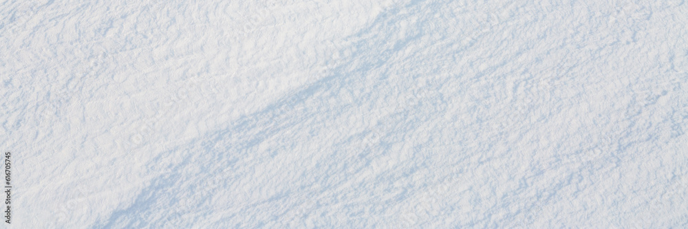 Beautiful winter background with snowy ground. Natural snow texture. Wind sculpted patterns on snow surface. Wide panoramic texture for background and design. Beautiful winter background with snowy ground. Natural snow texture. Wind sculpted patterns on snow surface. Wide panoramic texture for background and design.