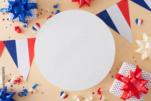 Idea for a spirited Bastille Day celebration. Top-down view of gift boxes, bows, french flag garlands, patriotic glitter, hearts, stars on pastel beige background with blank circle for ads or text