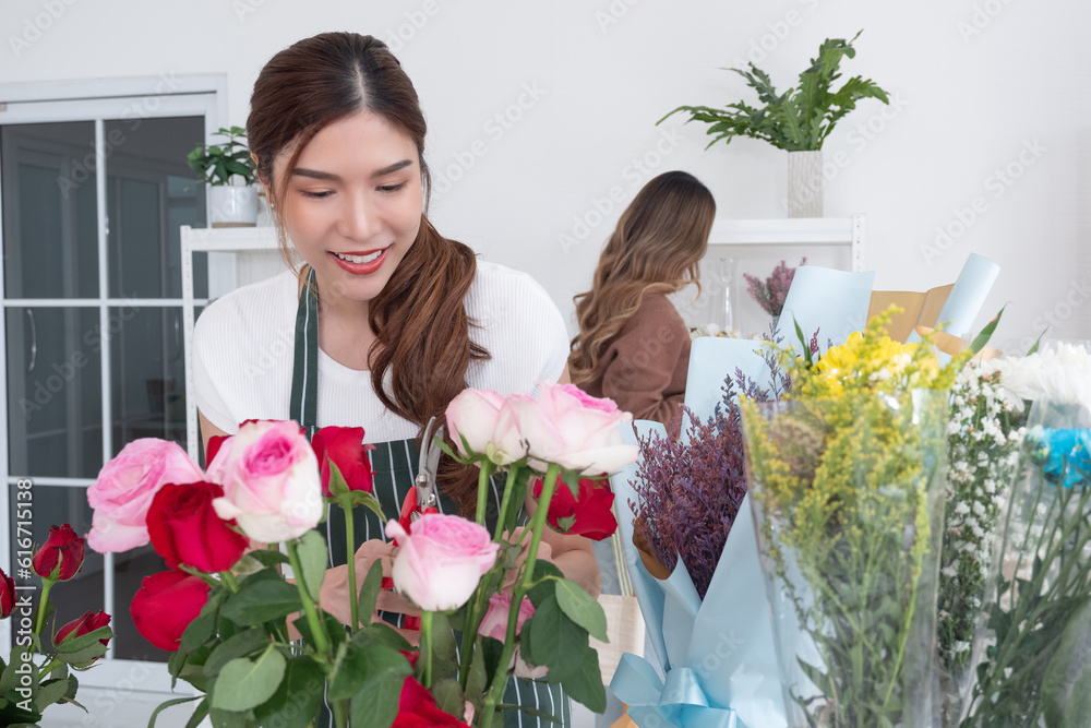 Two beautiful Asian florists work together in her own shop. Small business, Owner business.