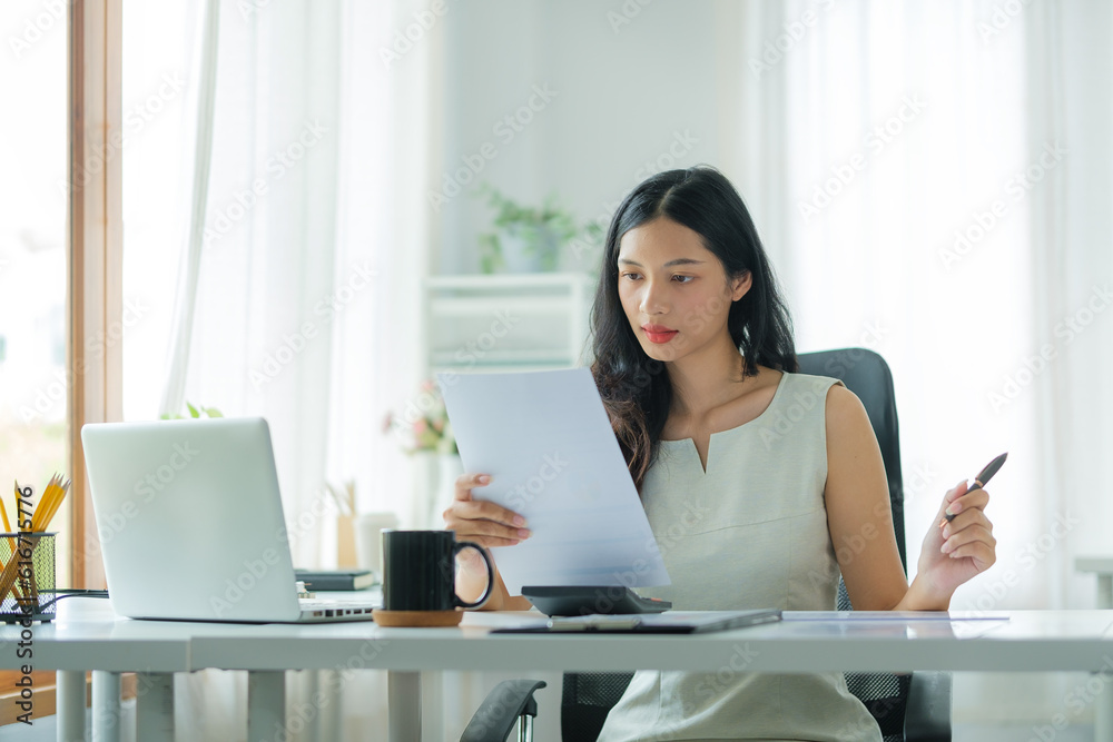 Professional female accountant working with financial statistics graphs at office desk.. Professional female accountant working with financial statistics graphs at office desk..