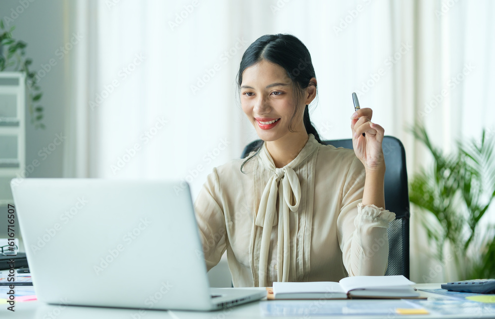 Charming young businesswoman reading email on laptop computer at working desk. Charming young businesswoman reading email on laptop computer at working desk.