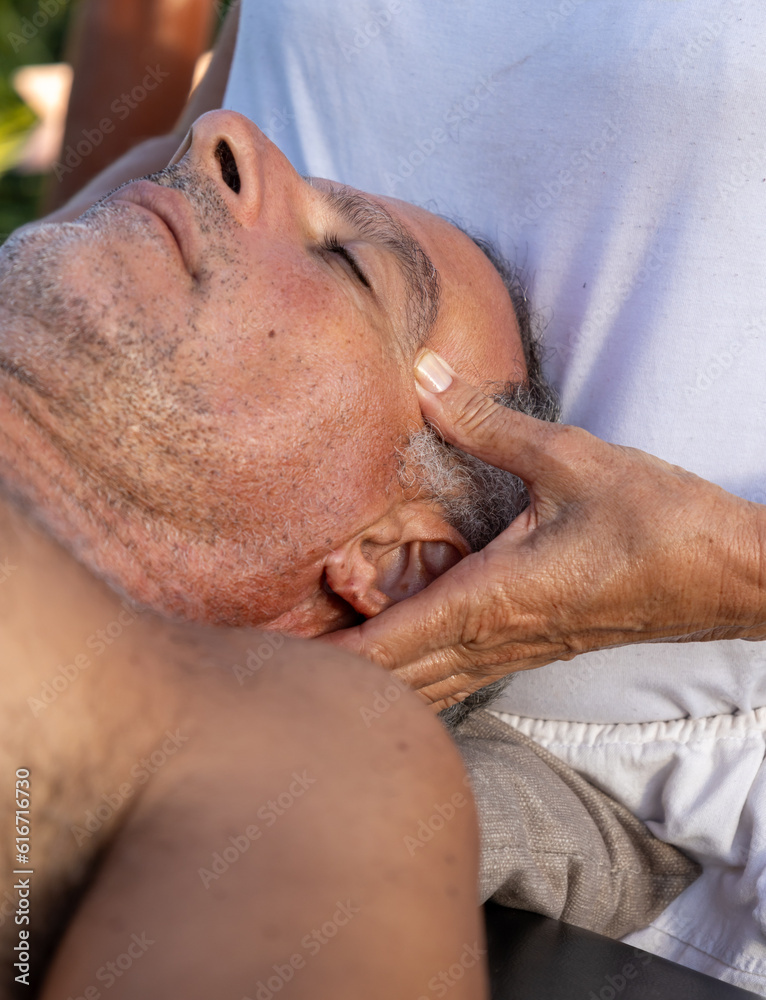 Massage session at a resort. Masseur and his patient taking massage outdoors. Massage session at a resort. Masseur and his patient taking massage outdoors.
