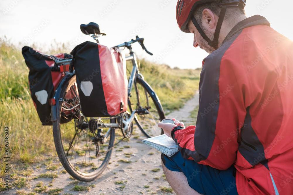 Touring cyclist using compass on map. Stock Photo  Adobe Stock
