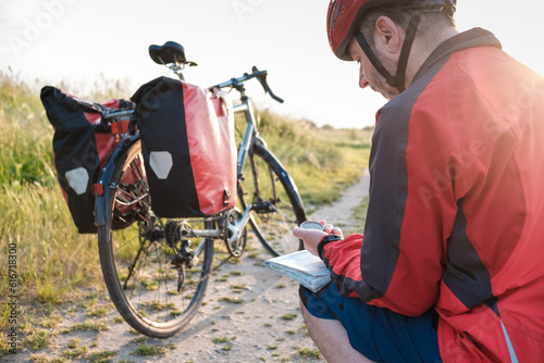Cuadro en lienzo Touring cyclist using compass on map.